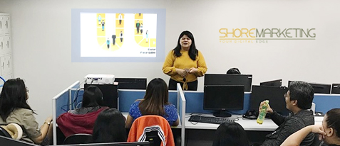 A ShoreMarketing employee (the Marketing department of Shore360, Inc.) discussing with her teammates.