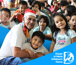 Lee Shaddock, the CEO of Shore360, Inc. with some smiling children from the Duyan ni Maria Children's Home.