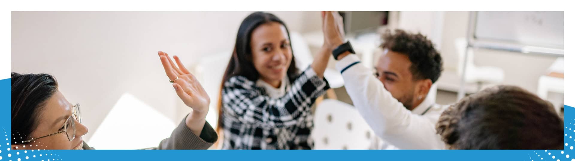 A group of diverse team members celebrating success with high-fives in a bright office setting, fostering collaboration and positivity.