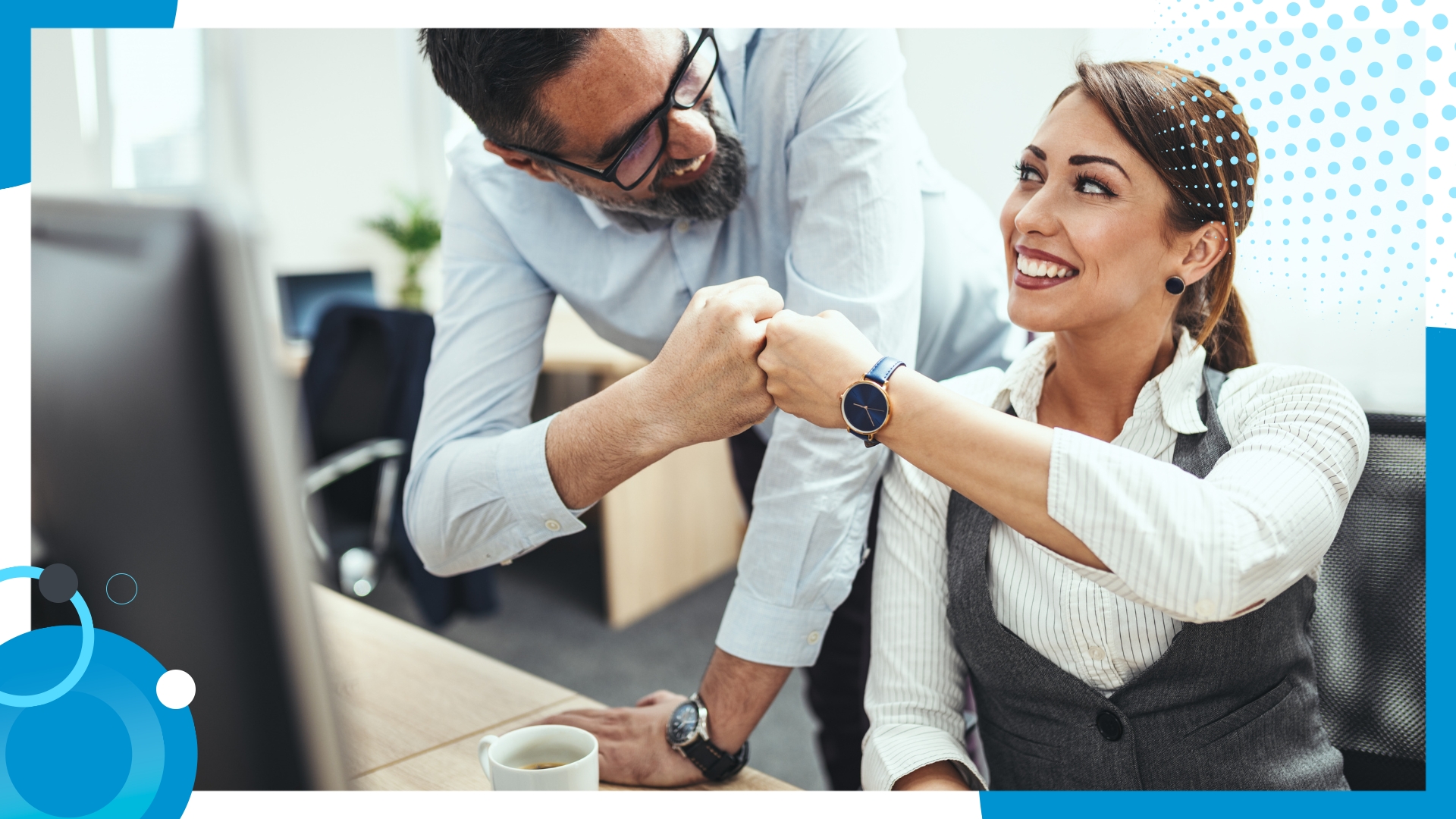 Two colleagues in an office celebrating success with a fist bump, smiling and engaged in a positive interaction.