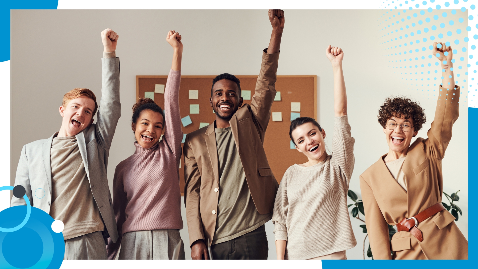 Group of happy business professionals raising their fists in celebration in an office setting