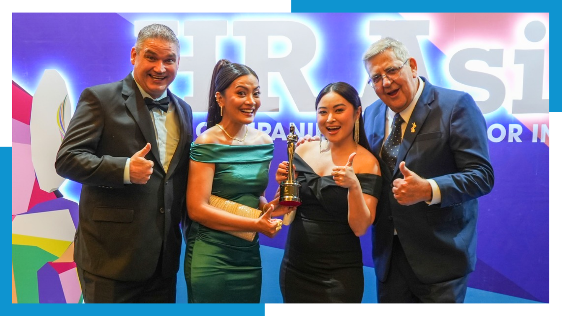 Two male and two female professionals, including Western and Filipino leaders, dressed in formal attire, proudly hold a trophy. They are smiling and giving thumbs-up gestures in front of an "HR Asia" banner, celebrating a company award.
