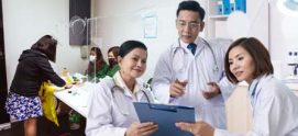 A photo of doctors with a patient registering at the background.